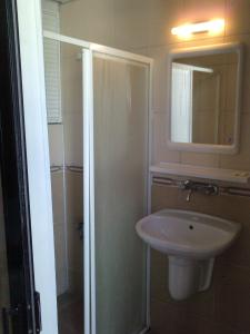 a bathroom with a sink and a shower and a mirror at Hotel Melike in Kuşadası