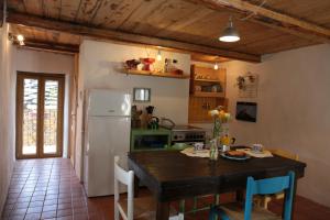 a kitchen with a table and a refrigerator at Casa Acquarossa in Rubiana