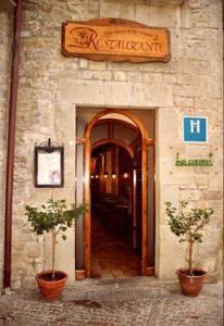 una entrada a un restaurante con dos macetas delante en Hostal Las Coronas, en Sos del Rey Católico
