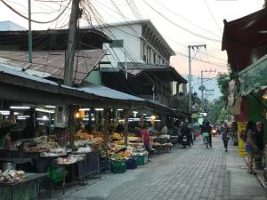 eine Gruppe von Menschen, die auf einem Markt mit Obst und Gemüse herumlaufen in der Unterkunft Meechok Home in Chiang Mai