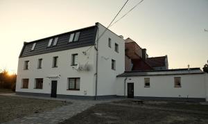 a white house with a black roof at Happy Day Apartments in Opole