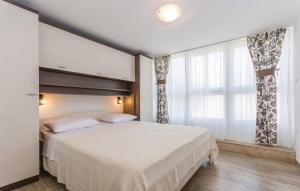a bedroom with a bed and a large window at Apartment Nena- apartman sa posebnim ulazom u prizemlju, terasom i zelenom okućnicom in Rakotule