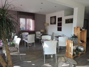 a dining room with white chairs and a table at Hotel le Foron in La Roche-sur-Foron