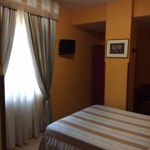 1 dormitorio con cama y ventana en Cristal Hotel, en Manocalzati