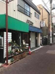 a street with a vegetable stand in front of a building at Guesthouse Sensu in Tokyo