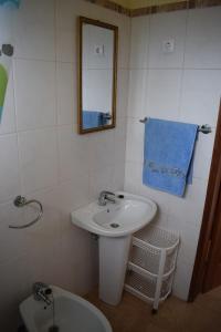 y baño con lavabo, espejo y aseo. en Apartamento Fritzi, en Ponta do Sol