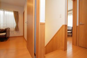 un pasillo con una puerta que conduce a una sala de estar en Fujinokura Village, en Fujikawaguchiko
