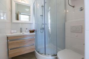 a bathroom with a shower and a toilet and a sink at Central Boutique Apartments with balconies, in walking distance to the sea in Zadar +36 photos