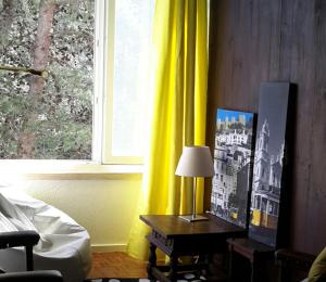 um quarto com uma cortina amarela e uma mesa com um candeeiro em Torre Mar Apartment em Cascais