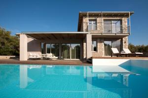 a house with a swimming pool in front of a house at Agrikies Villas in Lefkada Town