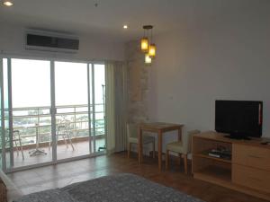 a living room with a television and a table with chairs at Apartments At View Talay in Pattaya South