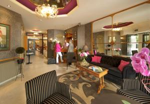- un salon avec un canapé, des chaises et des personnes dans l'établissement Hotel Figaro, à Knokke-Heist