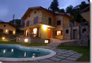 a house with a swimming pool in front of a house at Casa Tulipano Grande in Faggeto Lario 