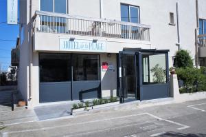 un bâtiment avec une porte ouverte dans une rue dans l'établissement Hotel de la Plage, à Gruissan