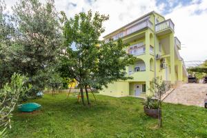 a yellow house with trees in front of it at Apartment Vilic in Pula