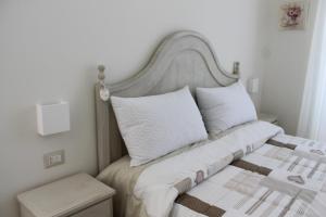 ナポリにあるB&B Pauraのベッドルーム1室(白いシーツと枕のベッド1台付)