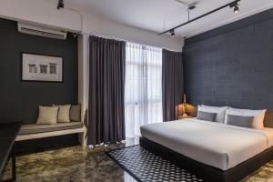 a bedroom with a large bed and a window at La Pause Hatyai in Hat Yai