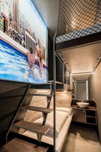 a bunk bed room with a tv and a sink at BoxHotel Göttingen (App Based Hotel) in Göttingen