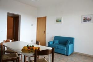 sala de estar con mesa y sofá azul en Surra Mediterranean Apartments en Scicli