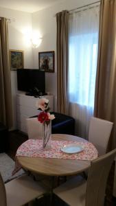 a dining room table with a vase with flowers on it at Apartment Ines in Split