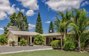 a motel with palm trees in front of it at Biloela Countryman Motel in Biloela