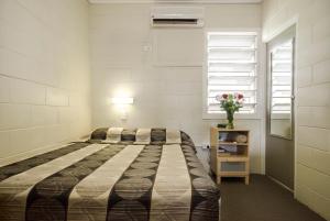a hotel room with two beds and two tables at Biloela Countryman Motel in Biloela