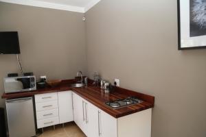 a kitchen with a counter with a stove and a microwave at Natures Haven in Roodepoort