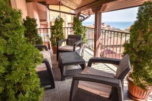 a balcony with wicker chairs and a view of the ocean at Dimitur Jekov Guest House in Obzor