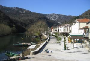 une ville avec une rivière avec des bateaux dans l'eau dans l'établissement Guest House PERJANIK, à Rijeka Crnojevića