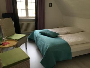 Das Ostseehotel في هوهفاخت: غرفة نوم بسريرين وكرسي ونافذة