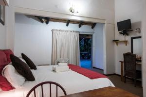 Un dormitorio con una gran cama blanca y una ventana en Khaya La Manzi Guest Lodge, en Hibberdene