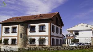 dom z kamienną ścianą obok budynku w obiekcie Apartamentos Rurales Monfragüe w mieście Torrejón el Rubio