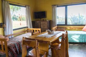 a dining room with a table and a bed and a window at Cabañas Luna Lunera in Tandil