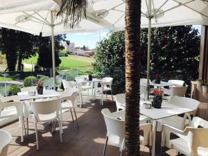 una fila de mesas y sillas con sombrillas blancas en Hotel Santiago Apóstol, en Santiago de Compostela