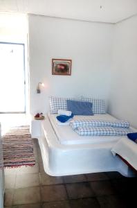a white bed in a room with a window at Rosys Little Village in Skala