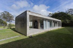 una pequeña casa con puertas de cristal en el césped en Villa Refuge Astrolabe, en Rabo de Peixe