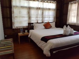 - une chambre avec 2 lits et une fenêtre avec des rideaux dans l'établissement Niwas Ayutthaya, à Phra Nakhon Si Ayutthaya