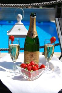 eine Flasche Wein und eine Schale Erdbeeren auf dem Tisch in der Unterkunft Hotel Rubens in De Haan