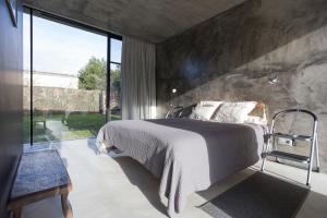a bedroom with a bed and a large window at Villa Refuge Astrolabe in Rabo de Peixe