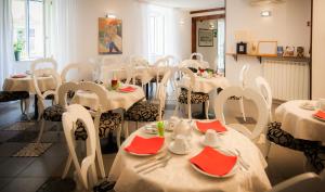 a dining room with white tables and chairs with red napkins at Hotel Centrale in Trieste
