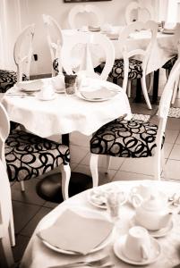 a black and white photo of a table and chairs with dishes at Hotel Centrale in Trieste