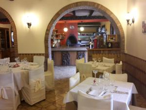 a restaurant with white tables and chairs and a kitchen at Antico Casale Le Fossate in Giove