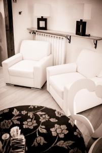 a living room with two white couches and a rug at Hotel Centrale in Trieste