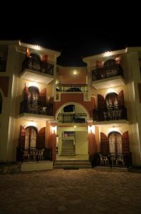 a large building with balconies at night at Castello Beach Hotel in Argasi