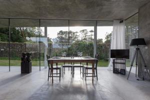 una sala da pranzo con tavolo, sedie e televisione di Villa Refuge Astrolabe a Rabo de Peixe