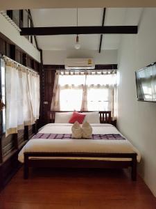 a bed sitting in a bedroom next to a window at Niwas Ayutthaya in Phra Nakhon Si Ayutthaya