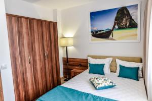 a bedroom with a large bed with blue pillows at Stela Apartments in Obzor
