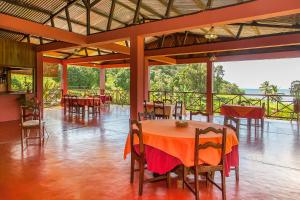 ein Restaurant mit Tischen und Stühlen und Meerblick in der Unterkunft Hotel Nautile in Sainte Marie