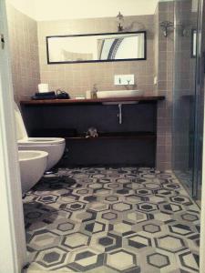 a bathroom with a toilet and a sink and a mirror at Oddi21 B&B in Albenga +15 photos