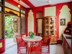a kitchen with red walls and a table with red chairs at Maruti Lane Villa in Ubud